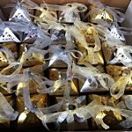 Christmas cakes wrapped in gold foil boxes and shiny ribbon ties