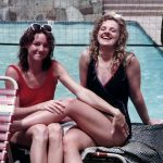 Photo of Rocky and me in swimming suits by the pool, laughing. 1990.